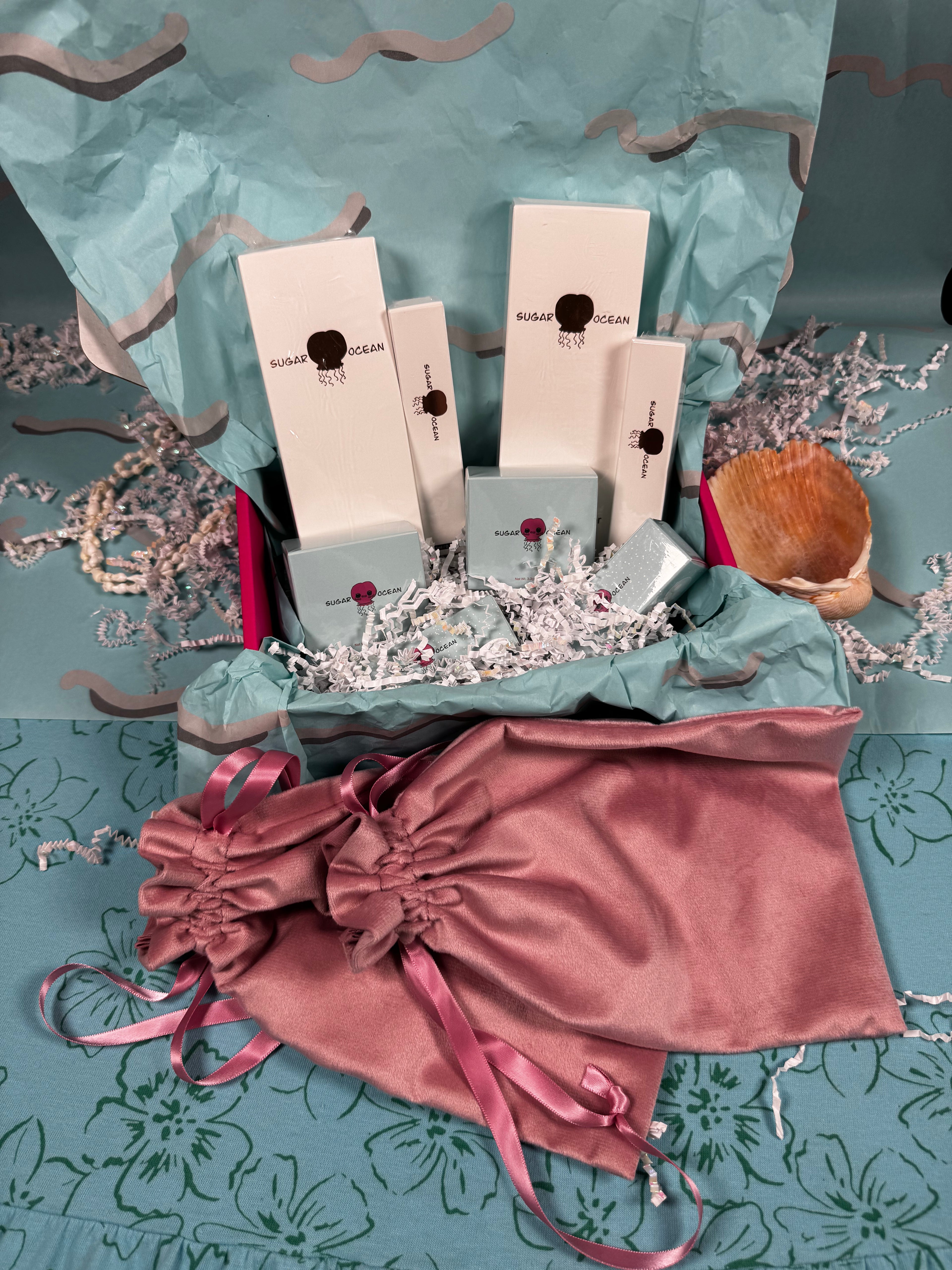 Makeup products and tools on a decorative blue background with a pink drawstring bag.